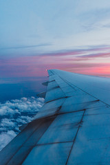 Fototapeta na wymiar View through window of an aircraft. Clouds and sunset sky 