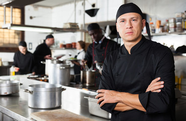 Confident male chef posing at restaurant kitchen