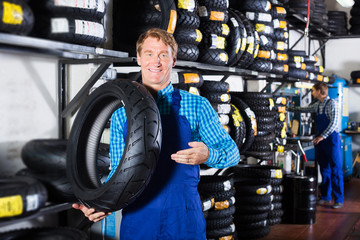 Fototapeta na wymiar Man standing with auto tires