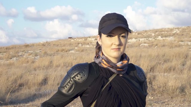 Dangerous Young biker woman gets off the bikemotorcycle and pulls the knife out of the scabbard
