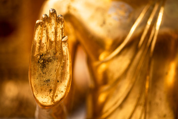 Hand of a golden Monday Buddha statue.