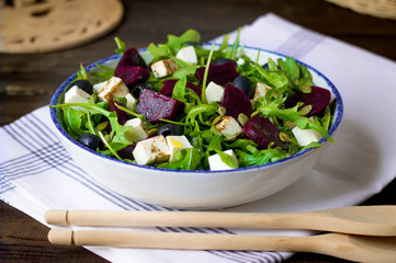 beetroot salad with  green rucola, olive oil,  cheese, olives, and pumpkin seeds
