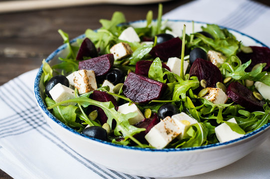 beetroot salad with  green rucola, olive oil,  cheese, olives, and pumpkin seeds