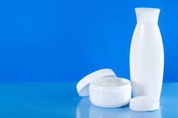 White jar of cream, gel shower, lotion beauty on blue background