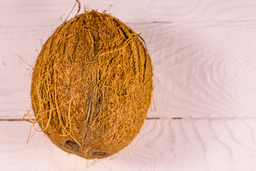 One whole coconut on a wooden table. Top view