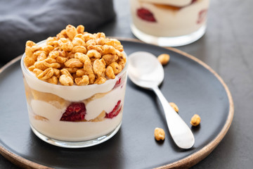 Fresh yoghurt with rasberry in clear glass. Raspberries in white bowl. Healthy morning breakfast.