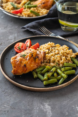 Grilled chicken thighs with bulgur, asparagus beans and tomatoes. Delicious lunch. Copy space.