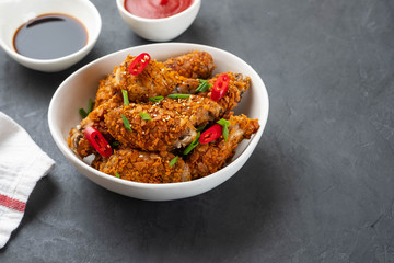 Chicken nuggets with sauce and pepper on a dark background. Copy space.