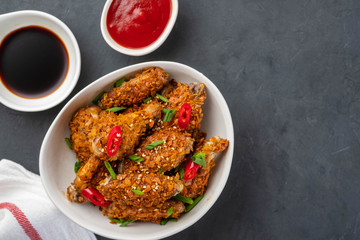 Chicken nuggets with sauce and pepper on a dark background. Copy space.