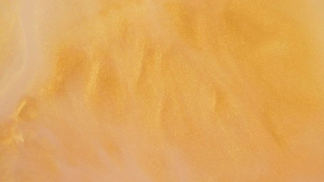 Colorful golden sand organically moves in colorful liquid
