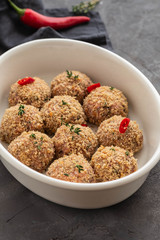 Raw fresh meatballs in the white plate on the white table. Copy space.