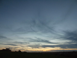 cloudy nighttime sunset sky blue sky treeline empty space