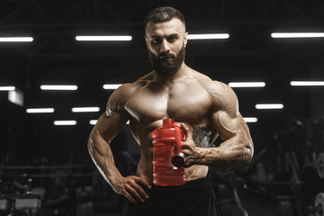 Naklejka na ściany i meble Handsome strong athletic muscles men drink water and sport nutrition workout bodybuilding concept background