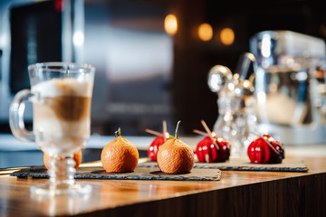 Handmade cakes covered with red glaze and cakes in the form of tangerines
