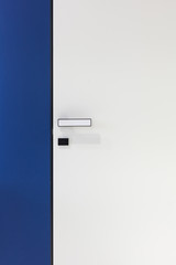 Photo of white modern door in deep blue wall