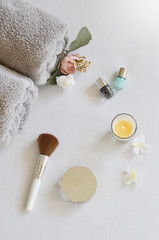 Beauty and bath products with candle on white background.