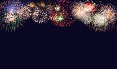 Composite of multiple firework explosions against dark blue sky with copy space for New Years or Independence day celebrations