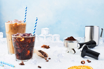 Summer drink iced coffee in a glass and ice coffee with cream in a tall glass surrounded by ice,...