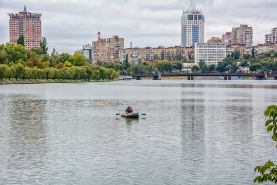 Fisherman on a boat on the river Kalmius in Donetsk rainy autumn