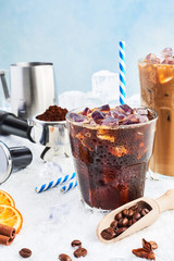 Summer drink iced coffee or soda in a glass and ice coffee with cream in a tall glass surrounded by...