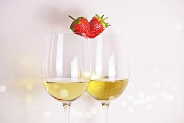 Two glasses of white wine with strawberry heart shape. Valentine's day concept 