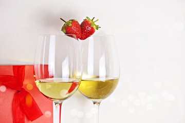 Two glasses of white wine with strawberry heart shape. Valentine's day concept 