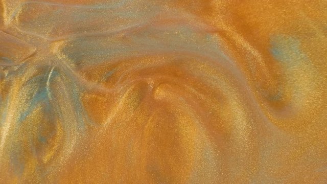 Colorful golden sand organically moves in colorful liquid