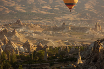 Beautiful landscape of Cappadocia valley with hot air balloons in background at sunrise