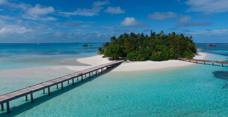 Fototapeta na wymiar Drone picture, aerial image of beautiful virgin island in Maldives with white sand and turquoise water and wooden bridge. Concept: travel magazine, honeymoon famous place