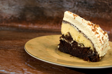Delicious Chocolate and Cream Cake with Icing on Rustic Looking Wood Vertical