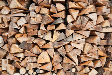 Pile of firewood, logs close-up. Natural wooden background. Reserve for winter and alternative energy source