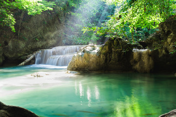 Erawan waterfall, National Park, Kanchanaburi, Thailand. Empty waterfall with sun rays shining through green foliage.