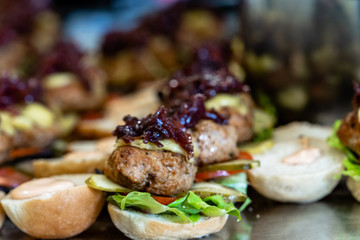 Closeup View of Sliced Bread Spread on the Table with Ingredients on them for Small Burgers