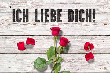 Rose und Blütenblätter auf Holzuntergrund und Nachricht 
