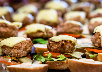 Closeup View of Sliced Bread Spread on the Table with Ingredients on them for Small Burgers