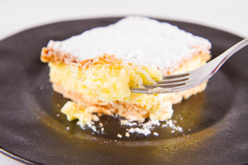 Napoleonka cake - a Polish type of cream pie - sprinkled with powdered sugar, eaten with a fork