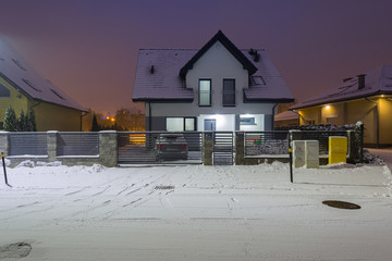 New house with stone fence at snowy night