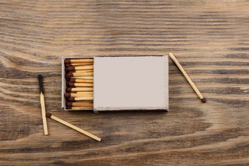 Matches with brown gray in a matchbox on a wooden table