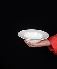 male hand holding empty white ceramic soup plate