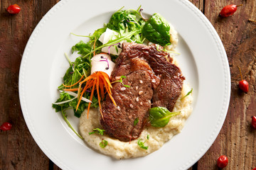 Rib-eye steak with sweet potato-herb purée and leaf lettuce
