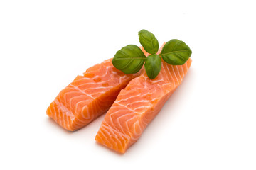 Fresh salmon fillet with basil on the white background.