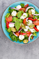 Vegetable salad with cheese mozzarella, tomatoes, basilikum and spice.