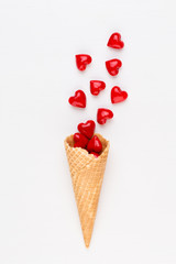 Creative composition for Valentines day with waffle cone, mixed hearts on white background top view. Fashion flat lay.