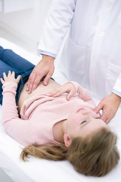 Doctor examining girl's abdomen
