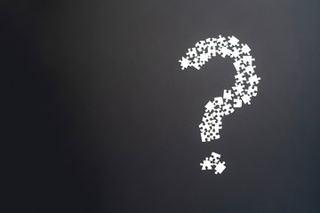 closeup puzze question mark on dark background isolated b