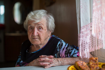 Portrait of an elderly woman has Breakfast sitting at home.