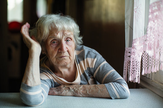 Portrait of a pensioner russian woman at the table in home.