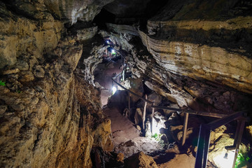 Enlighted lava tunnel with humid floor in the Galapagos island of Sand Cruz on the way to Puerto Ayora, Ecuador