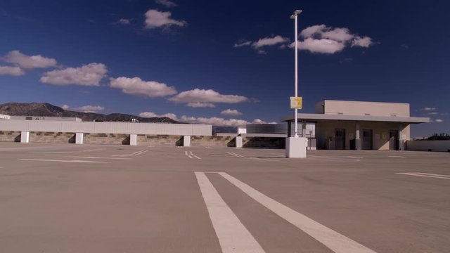 EMPTY ROOFTOP PARKING STRUCTURE.  4K, LOW ANGLE, SLIDER SHOT.  10 BIT, 4:2:2.