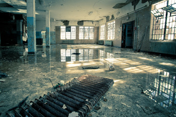 Interior of abandoned mental hospital with broken windows and water flood on floor